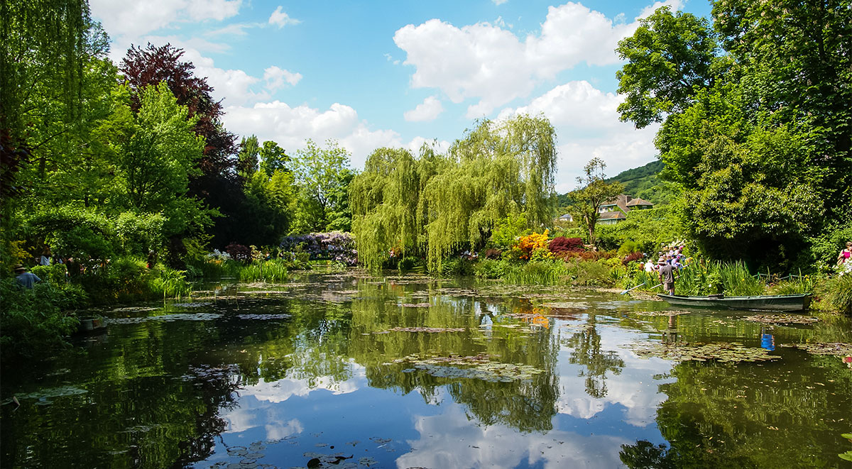The lily pad pond at Giverny created by Claude Monet with the wisteria-covered Japanese bridge in the background